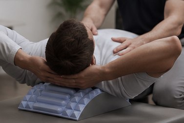 Hands supporting a client's shoulders during a guided stretch over the arch